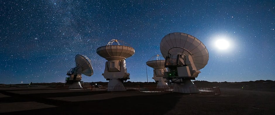 four antennas at the ALMA observatory pointing toward the sky