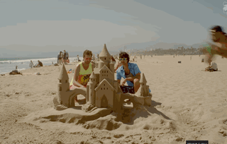 gif man jumping on and ruining a giant sand castle