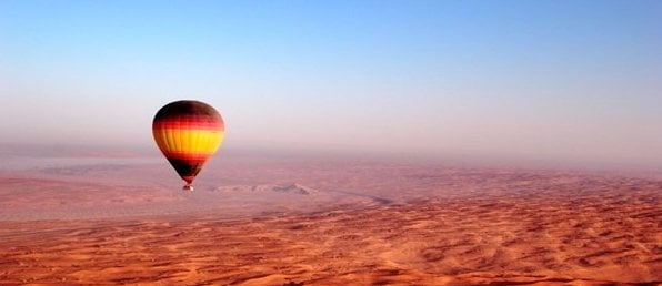 hot air ballon floating over desert