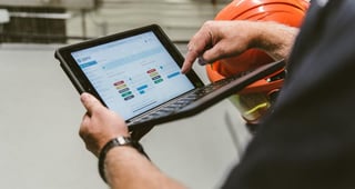 man holding a tablet with charts