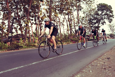 bikers biking in a line on a country road