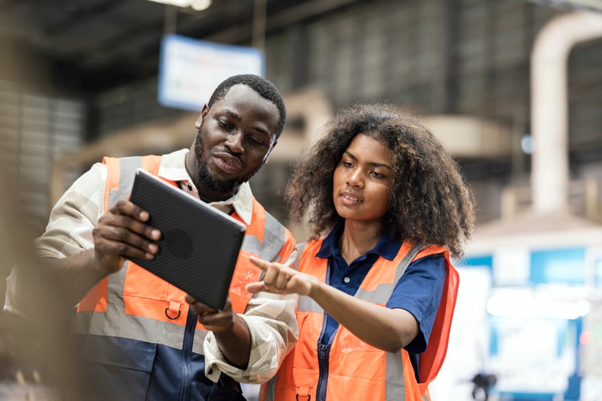 two manufacturers pointing at on ipad