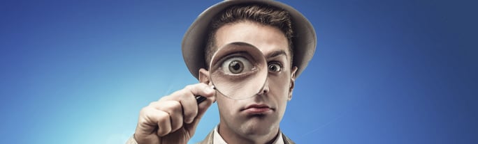 man looking through magnifying glass