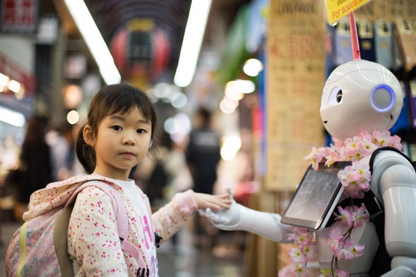 child and robot hand in hand