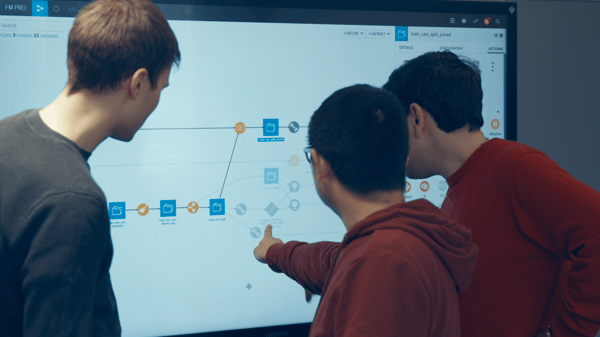 three men point to Dataiku DSS workflow on a screen
