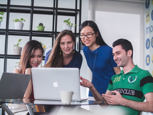 team looking at a laptop screen together