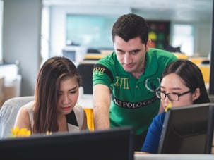 team of three working at computers